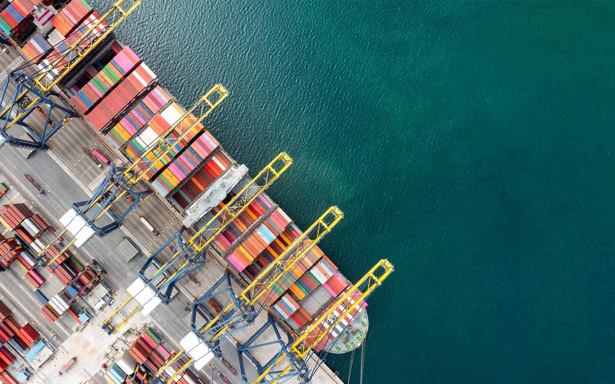 Top View Of International Container Ship Loading And Unloading At Sea Port | FW Logistics